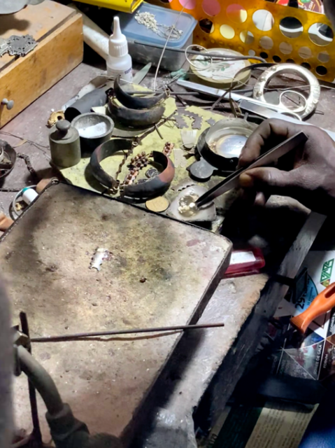 A person working on a piece of metal Description automatically generated
