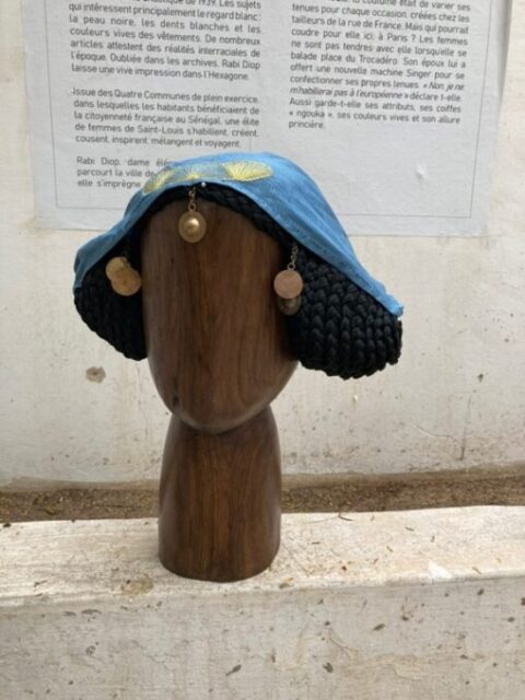 A wooden head with a hat on it Description automatically generated